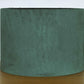 Green fabric lampshade on a wooden surface with a white background