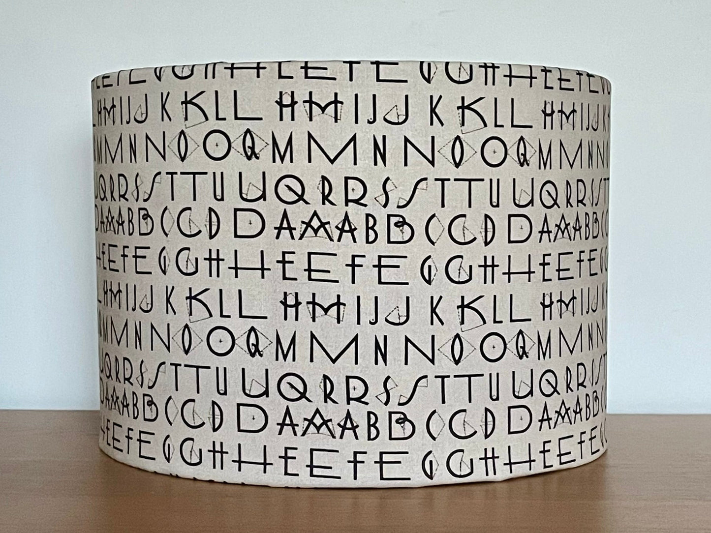 Tim Holtz Eclectic Elements charcoal fabric lampshade. Typography on a distressed cream background. With a choice of white or metallic lining.