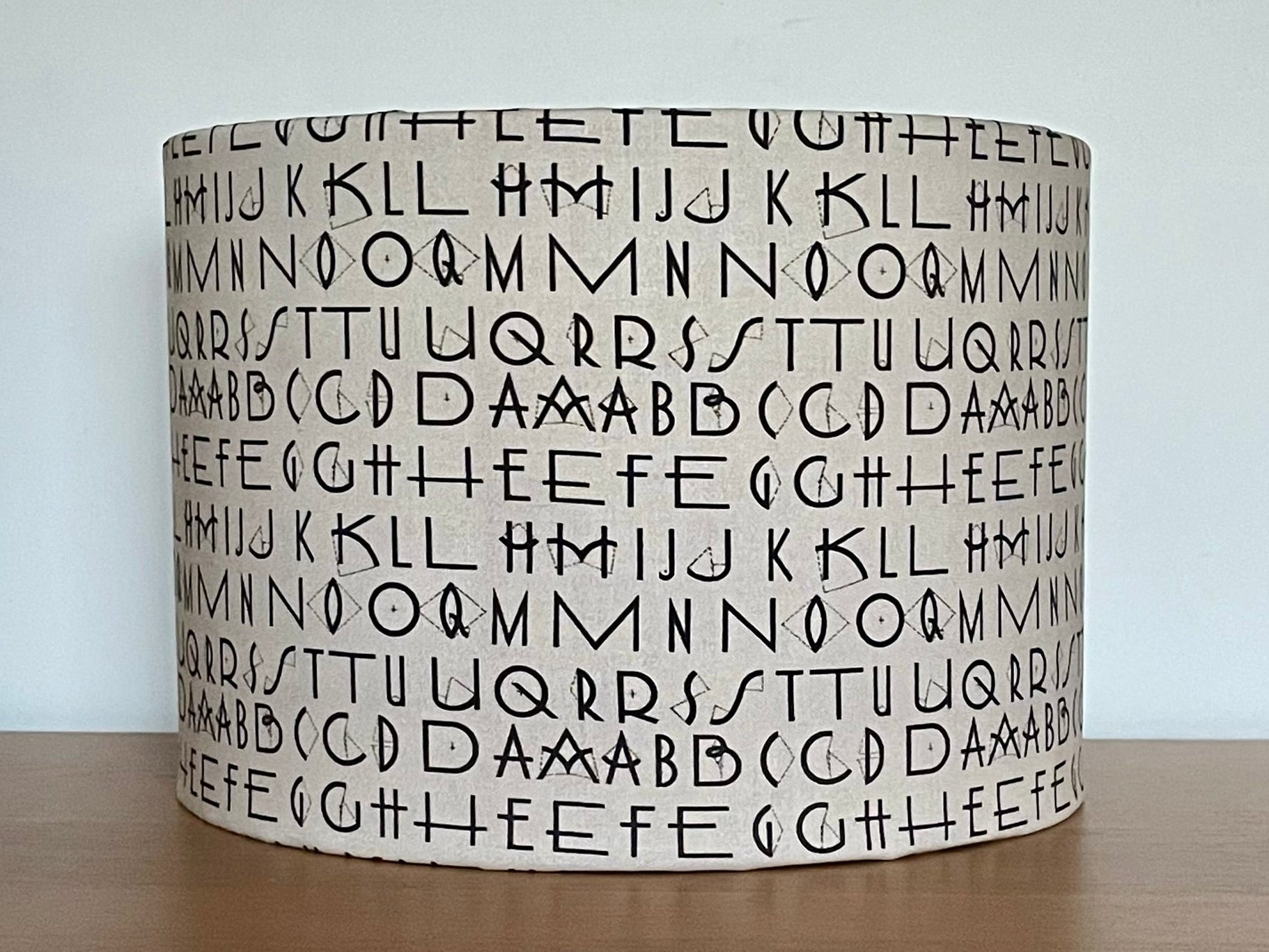 Tim Holtz Eclectic Elements charcoal fabric lampshade. Typography on a distressed cream background. With a choice of white or metallic lining.