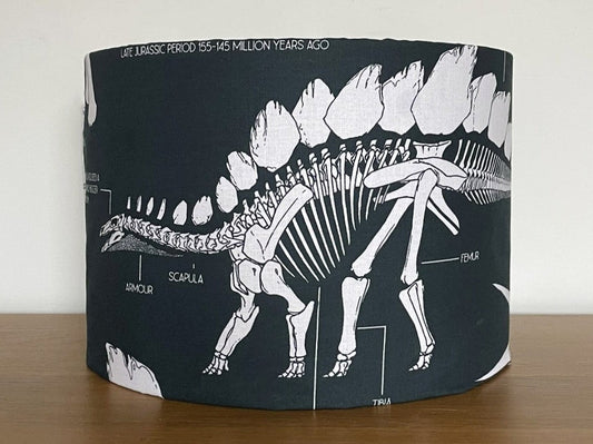 Lampshade with dinosaur skeleton design on a wooden surface