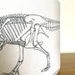 Lampshade with a black line drawing of a dinosaur skeleton on a white background